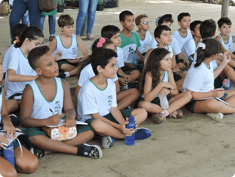 crianças sentadas em um espaço aberto